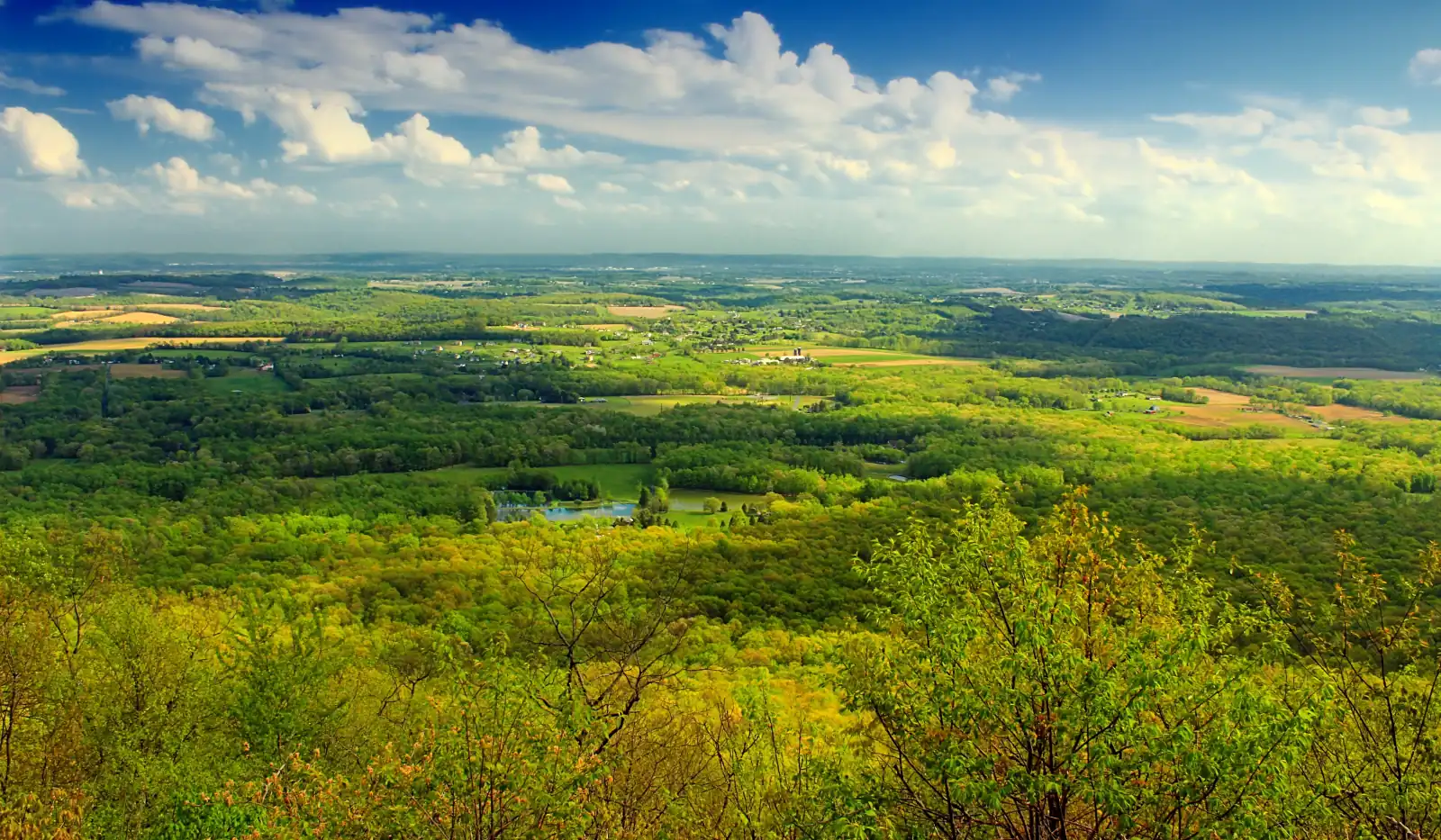Spring view over the green farmland and wooded hills of the Lehigh Valley from the Appalachian Trail overlook near Delps, Pennsylvania.