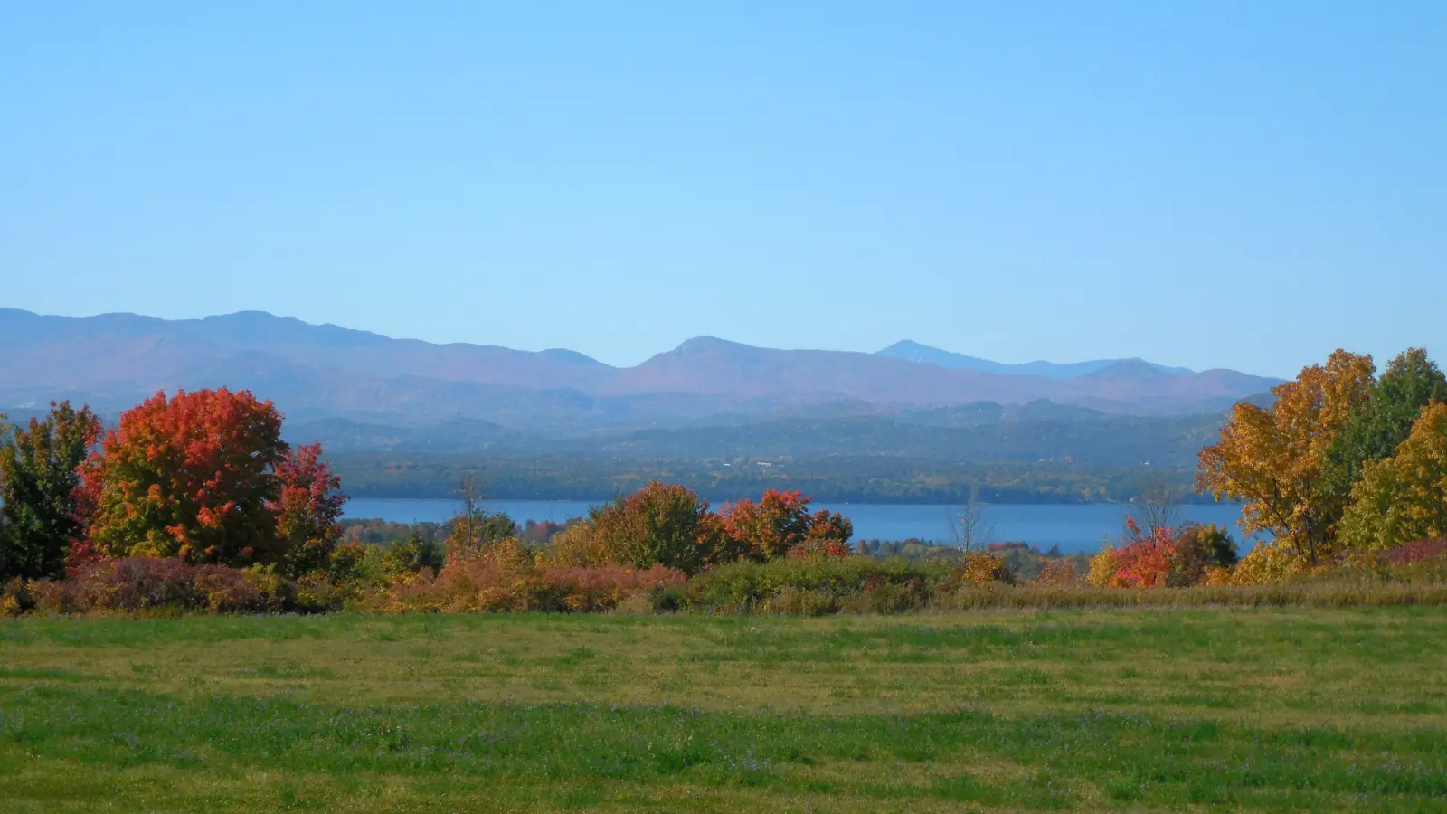 Autumn view west over a Vermont meadow to Lake Champlain and the Adirondack Mountains from Charlotte, Vermont.